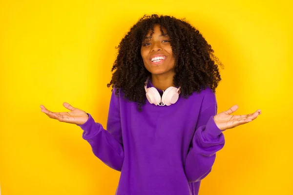 アフリカ系アメリカ人女性は黄色の背景で腕を振り笑います 感情やジェスチャーの概念 — ストック写真