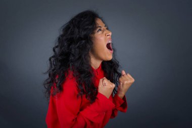 Esmer kadın zafer kazanmaktan heyecan duyuyor ve mutlu. Yumruklarını sıkıyor, gözleri kapalı çığlıklar atıyor. Üniversitedeki tüm sınavları geçtiği için mutlu..