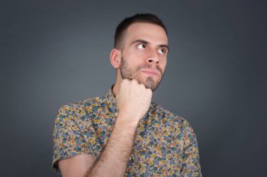 Düşünceli bir adamın portresi elini çenesinin altında tutar, bir şey hatırlamaya çalışır ya da ilginç bir şey dinler, sıradan giyinir, içeride poz verir. Gençlik kavramı.