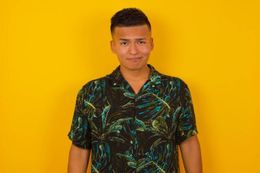 Düşüncelere dalmış, kaşlarını kaldırmış, dudaklarını kıvırmış, şık kıyafetler giymiş, metnin için kopya alanı olan duvarlara yaslanmış düşünceli, çekici İspanyol bir adam..