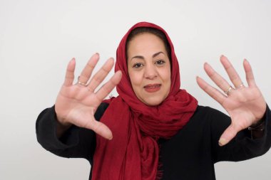 El hareketli parmak çerçevesi. Kameraya bakıp el hareketi yapan güzel bir genç kadının portresi. Stüdyoda poz veren başörtüsü takan orta yaşlı bir Arap kadın.