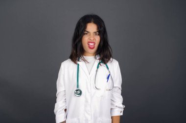 İğrençti. Güzel bayan doktor, düz saçlarıyla gri duvara poz verdi. Yüzünü buruşturdu..