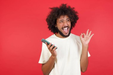 Kızıl duvarda afro saçlı genç adam iyi görünüyor.   