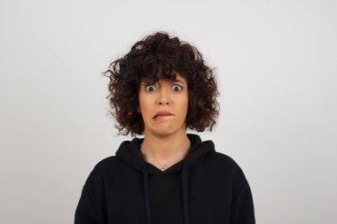 Güzel genç kadın gergin ve korkmuş dudaklar ısırıyor. Sabırsız bir ifadeyle kameraya bakıyor. Düşünceli. 