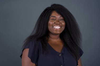 Sevimli Afro-Amerikalı kadın mutlu bir ifadeyle gözlerini kırpıyor. Yüz ifadeleri ve insanların duygu konsepti.