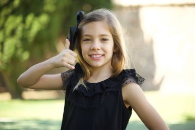 Siyah elbiseli çekici genç kız telefon konuşmasını taklit ediyor, elini kulağına yaklaştırıyor, sanki cep telefonu tutuyormuş gibi, kendine güvenen bir yüz ifadesi var. Ara beni.!