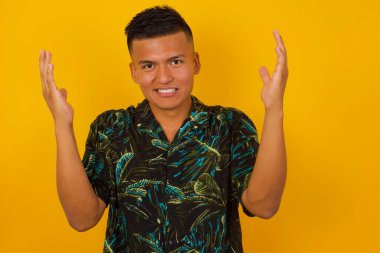 Neşeli İspanyol adam hoş geldin jesti yapıyor. Arka planda izole edilmiş kollarını kaldırıyor..