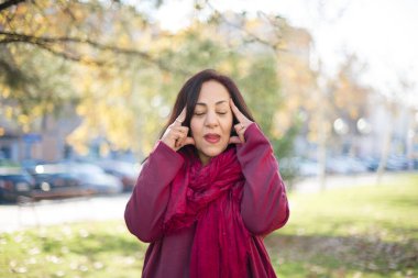 Parkta baş ağrısı olan orta yaşlı güzel bir Arap kadın.  