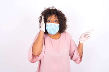 Yüz maskesi takan kadın ve günlük giysiler beyaz stüdyo arka planında izole edilmiş.