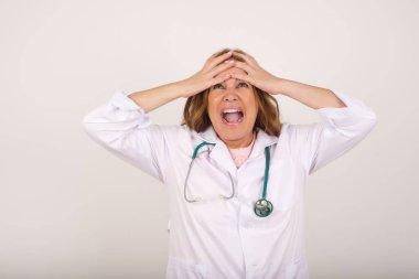 Korkunç, stres, şok. Kafkasyalı olgun kadın doktor portresi. Kafa tokuşturuyor. İnsani duygular, yüz ifadesi kavramı.