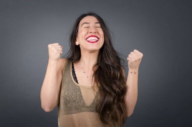 Stüdyoda yumruklarıyla poz veren genç ve güzel bir kadın. 