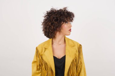 Ciddi, saf cilde sahip bir kadının profili, üzerinde fotokopi alanı olan gri stüdyo duvarının üzerinde yürümeye hazır düşünceli bir ifadeye sahiptir..