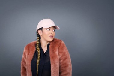 Pembe şapkalı kadın portresi kafa karıştırıcı bir şekilde yana bakıyor, kötü hatasını fark ediyor, reklam ve promosyon geçmişiniz için fotokopi alanına karşı poz veriyor..