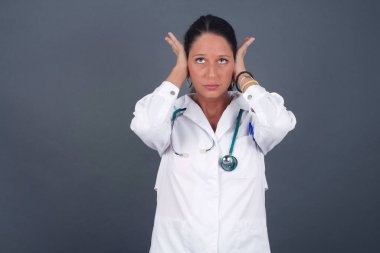 Elleriyle kulaklarını tıkayan doktor kadın hard rock veya yüksek sesle müzik dinlemek istemiyor. Avrupalı genç bir kadın gürültüyü ya da gürültüyü görmezden geliyor ya da elleriyle kulaklarını kapatıyor ve sokakta yüksek seslerden kaçınıyor. 