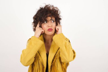 Düşünceli bir yüzü olan hayalperest bir kadın, yüzünü çevirmiş, hoş bir şeyler düşünüyor, gri duvara karşı poz veriyor..