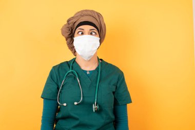 Yeşil üniformalı komik, genç, güzel, Müslüman doktor kadın tuhaf bir ifadeyle şaşı bakıyor, yalnız eğleniyor, dudaklarını buruşturuyor, bütün gün sonra suratını ekşitiyor, aptallaştırıyor..