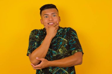 Endişe - yakışıklı bir İspanyol erkeğin kavramsal görüntüsüdür. Ağzını elleriyle kapatır ve içeride durur. Bir şeyden korktun. 