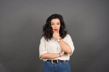 Genç, güzel, esmer bir kadın. Stüdyoda poz veriyor. 