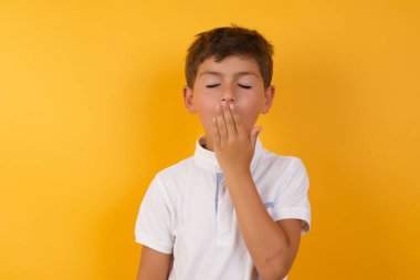 Sarı duvara yaslanmış tatlı çocuk.  