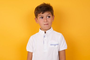 Tatlı çocuk sarı duvara bakıyor.  