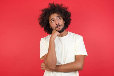 Kızıl duvara bakan afro saçlı genç adam. 