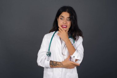 Endişe - güzel bir beyaz kadın doktorun kavramsal görüntüsüdür. Ağzını kapalı ve kapalı bir yerde duran. Bir şeyden korktun.