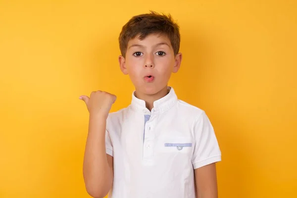 Cute Boy Pointing Back Yellow Wall — Stock Photo, Image