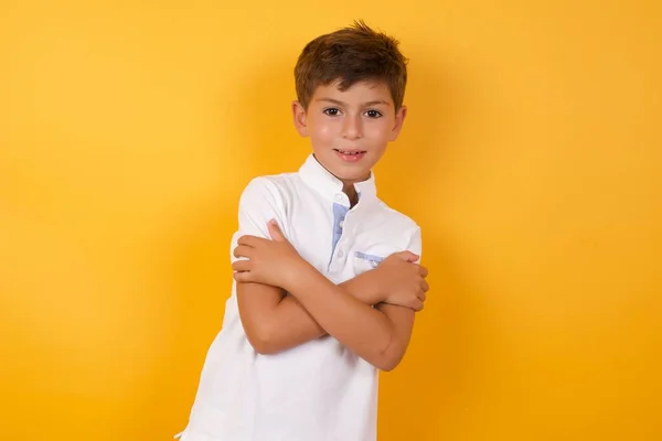 Menino Bonito Com Braços Cruzados Contra Parede Amarela — Fotografia de Stock