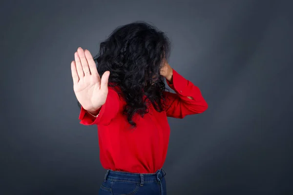 People, body language. Young European blue eyed woman covers eyes with palm and doing stop gesture, tries to hide from everybody. Don\'t look at me, I don\'t want to see, feels ashamed or scared.