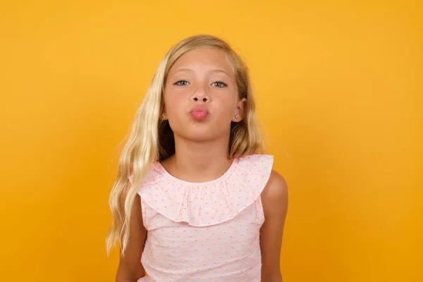 Menina Bonito Vestido Rosa Mostrando Beijo Fundo Amarelo — Fotografia de Stock