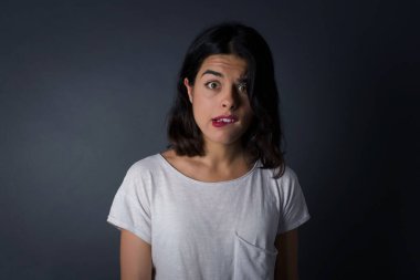 Güzel genç kadın gergin ve korkmuş dudaklar ısırıyor. Sabırsız bir ifadeyle kameraya bakıyor. Düşünceli. 