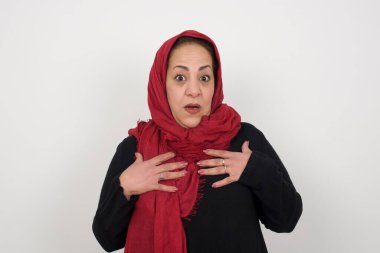 Şok olmuş güzel olgun Müslüman kadın ellerini göğsünde tutuyor, ağzı sonuna kadar açık, kameraya bakıyor faturaları ödemeyi unuttuğunu fark ediyor, büyük para cezası alıyor.