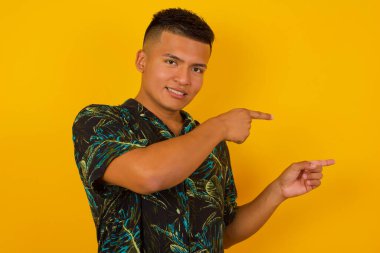 Olumlu, çekici, genç, İspanyol bir erkek, neşeli ve şaşkın bir ifadeyle, ağzı açık, içeride inanılmaz bir şey gösteriyor. Reklam kavramı.