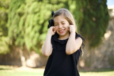 Bu sinir bozucu sesi çıkarmayı kes! Mutsuz, gergin, endişeli, kulaklarını parmaklarıyla tıkayan, üst katındaki komşularından gelen gürültüden rahatsız olan genç bir kızın vesikalığı..