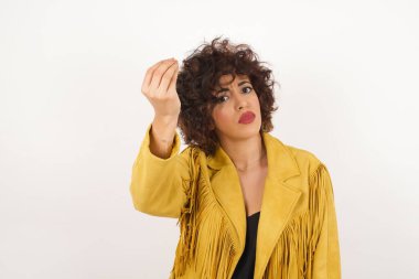 What the hell are you talking about. Shot of frustrated young  woman gesturing with raised hand doing Italian gesture, frowning, being displeased and confused with dumb question.