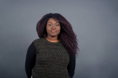 Güzel, Afro-Amerikalı bir kadının, hoş bir gülümseme ile kameraya bakarken boş fotokopi duvarına poz verirken ki görüntülerini kapatın.