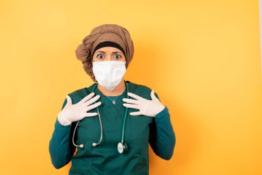 Şok olmuş, genç, güzel, yeşil üniformalı Müslüman doktor kadın ellerini göğsünün üstünde tutuyor, ağzı açık, kameraya bakıyor ve kapalı mekanda izole edilmiş faturaları ödemeyi unuttuğunu fark ediyor. Kız diyor ki: kim, ben?