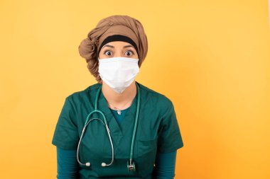 Yeşil üniformalı, ağzı açık, ağzı açık ve ağzı açık, şok olmuş bir şekilde 