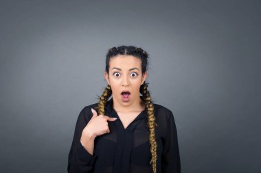 Şaşırmış güzel bir kadın sersemlemiş durumda, şaşkın bir şekilde kendini parmağıyla işaret ederek 