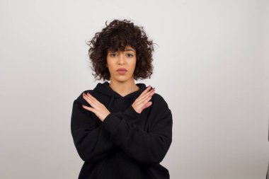 Reddedilmiş güzel esmer bir kız. Kızgın bir ifade takınıyor ve olumsuz işaretleri reddediyor..