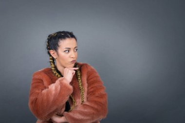 Neşeli bir kadının stüdyo çekimi, arkadaşlarının doğum gününde hazırladığı sürpriz için gri arka planda izole edilmiş..