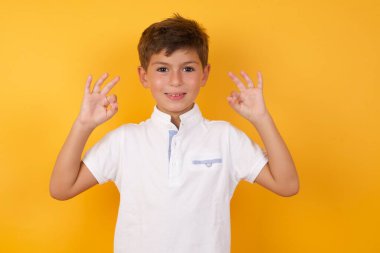 Yakışıklı çocuk sarı duvarda iyi görünüyor.  