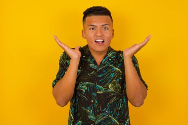 Şaşırmış genç bir adamın portresi. İnanamamasına şaşırmış görünüyor. Ağzın açık, yüzün yanında ellerin var..