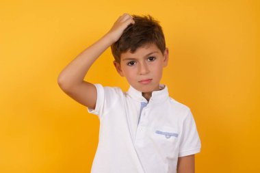 Sarı duvara karşı düşünen tatlı çocuk.  