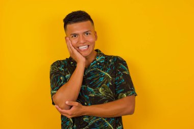 Şaşırtıcı derecede yakışıklı bir adam. İspanyol 'un yakından çekilmiş portresi, ağzı açık, ağzı açık, eli yüze yakın bir şekilde şaşkınlıkla bakıyor. Olumlu duygu yüz ifadesi vücut dili. 