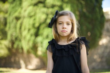 Kasvetli, sıkılmış, siyah elbiseli tatlı bir kız. Yüzümü buruşturdum, yukarı baktım, ellerimi indirdim, yorgun hissediyorum ve gitmek istiyorum..