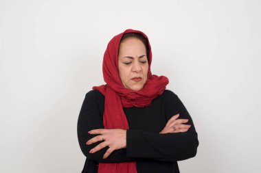 Closeup portrait displeased pissed off angry grumpy mature muslim woman with bad attitude, arms crossed looking sideways. Negative human emotion facial expression feelings