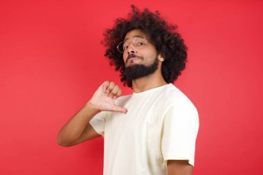 Kızıl duvara dayanmış afro saçlı genç bir adam.   