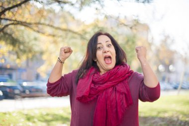 Parkta yumrukları olan orta yaşlı güzel bir Arap kadın.  