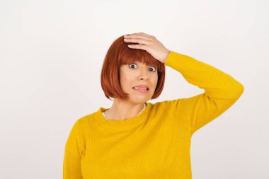 Tüh, ne yaptım ben? Güzel bir kadın, korkmuş ve pişmanlık dolu bir ifadeyle elini alnından tutuyor. Ayakta günlük giysiler giyiyordu.